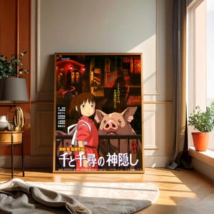 May include: Framed poster featuring artwork from the animated film "Spirited Away." The image shows a young girl in a red outfit with a pig, set against a backdrop of a Japanese town. The poster includes Japanese text.