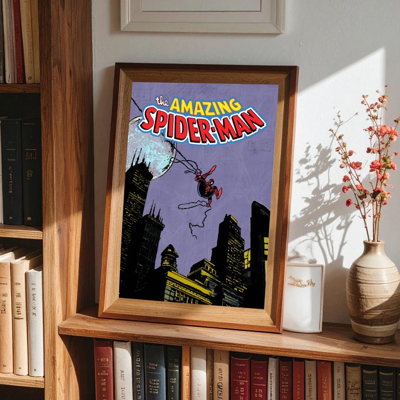 May include: Framed print of a vintage comic book cover featuring Spider-Man swinging through a city at night. The title "The Amazing Spider-Man" is displayed in red and blue. The artwork is set against a purple sky.