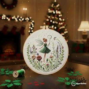 Puede incluir: Arte de aro de hadas bordado con un hada con un vestido verde con detalles florales y vegetales. El hada sostiene un lazo. El bordado está colocado en un aro de madera. El fondo incluye un árbol de Navidad y una chimenea.
