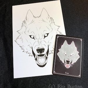 May include: A black and white line drawing of a wolf's head with a snarling expression. The wolf's eyes are highlighted in white. The drawing is on a white background. The image also includes a card with a similar image of a wolf's head, but in a gray tone, on a black background. The card has the word "FIRE" printed on it.