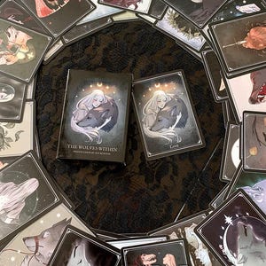 May include: A deck of oracle cards called "The Wolves Within" by Ritu Burton. The cards feature illustrations of wolves and women in a dark, mystical style. The box is black with silver lettering and a crescent moon design.