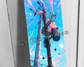 May include: Vertical art print depicting utility poles against a blue sky with pink cherry blossoms. The artwork features stars and a crescent moon. The artist's name, Rio Burton, is visible in the image.