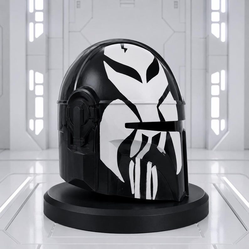 May include: A black helmet with a white graphic design, displayed on a black stand. The helmet's design features a stylized skull-like pattern across the front and top, with a glossy finish. The background is a white, futuristic-looking room.