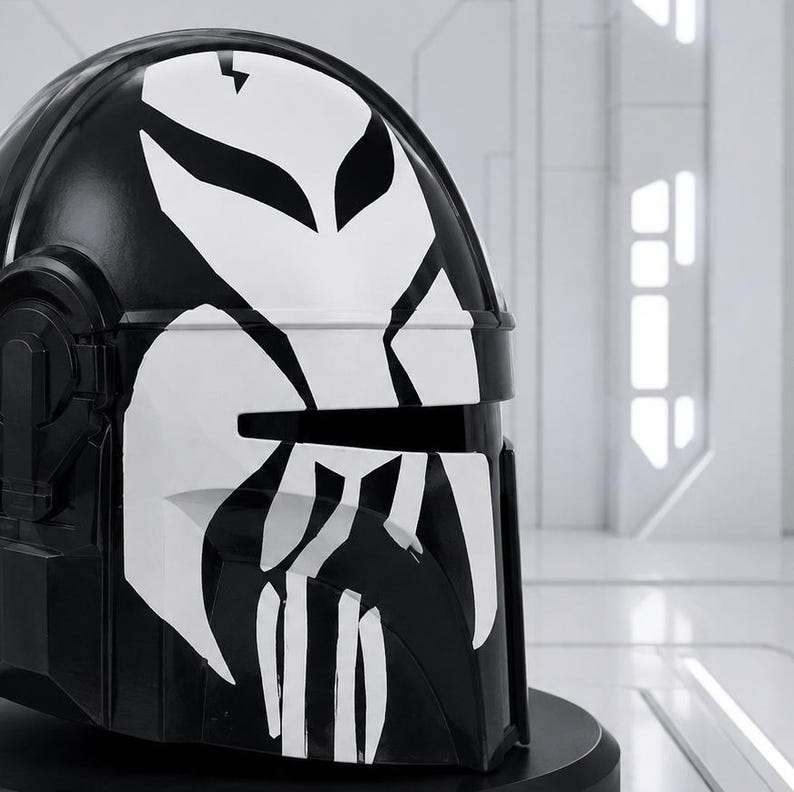 May include: A black helmet with a white graphic design. The helmet has a glossy finish and a distinctive, stylized face design in white. The design includes a lightning bolt and angular shapes. The helmet is likely for cosplay or display.