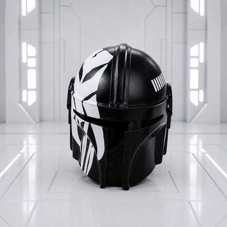 May include: A black and white Mandalorian helmet with a distinctive design. The helmet features a glossy black finish with white graphic accents on the top and face. The design includes vertical stripes and a series of parallel lines on the back.