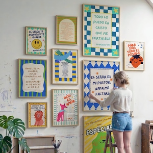 May include: A display of framed art prints with vibrant illustrations and Spanish text. The prints showcase diverse designs, such as a smiley face, a strawberry, a fox, and a lion. The frames are in natural wood tones.