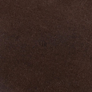 Könnte beinhalten: Nahaufnahme eines dunkelbraunen, strukturierten Stoffes. Das Material scheint ein dichtes Gewebe mit einer leicht unebenen Oberfläche zu sein. Die Farbe ist ein sattes, warmes Braun mit subtilen Farbvariationen.