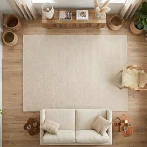 Top-down view of a plush, cream-colored hand-tufted shag rug styled in a modern bohemian living room with a neutral sofa, wooden furniture, and natural woven accents.
