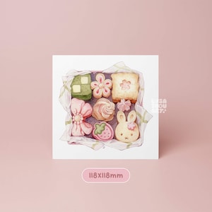 May include: A watercolour illustration of a box of assorted biscuits. The biscuits include a green square, a flower, a square with a flower, a bow, a swirl, a strawberry, and a bunny. The box is 118x118mm.