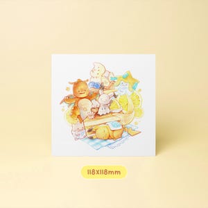May include: Square art print featuring cartoon characters, a cake, and lemon slices. The print has a white background and a yellow border. The print measures 118mm x 118mm.