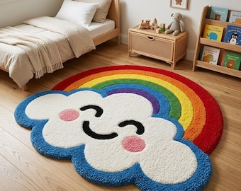 Könnte beinhalten: Ein getufteter Teppich in Form einer lächelnden weißen Wolke mit rosa Wangen, der über einem leuchtenden Regenbogenbogen mit roten, orangen, gelben, grünen, blauen und violetten Streifen liegt. Der Teppich hat einen dichten, texturierten Flor.