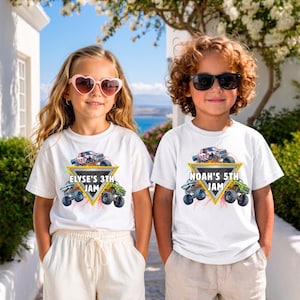 May include: Two children wearing white t-shirts with a monster truck graphic. The shirts have a yellow triangle with the text "ELYSE'S 3TH JAM" and "NOAH'S 5TH JAM". The shirts feature a red, white, and blue monster truck design.