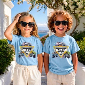May include: Two children wearing light blue t-shirts with a monster truck graphic. The shirts have text that reads "ELYSE'S 3TH JAM" and "NOAH'S 5TH JAM". The children are wearing sunglasses and standing outdoors.
