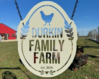 May include: A white metal sign with a chicken silhouette, the text "Durkin Family Farm", and the date "est. 2024". The sign is hanging from a black metal chain.