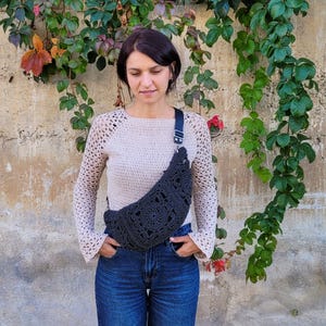 Model wearing a boho crochet crossbody bag made with paper yarn – lightweight summer sling bag with zipper closure and lining.