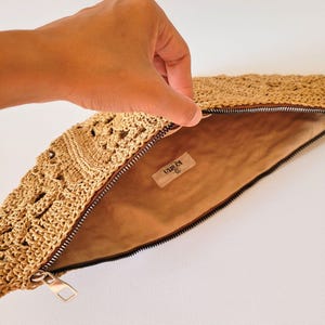 Inside view of the lined crochet bag, showing zipper and inner fabric details from the pattern tutorial.