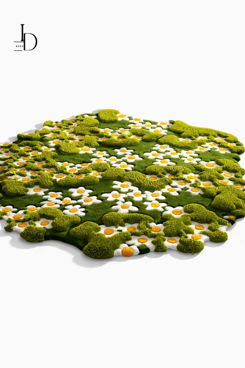 May include: A whimsical, green rug shaped like a field of flowers. The rug features white daisies with yellow centers and patches of textured green, resembling moss. The rug is on a white background.