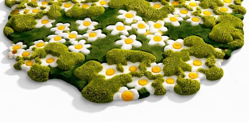 May include: A whimsical rug featuring a design of white daisies with yellow centers and green foliage. The rug has a unique, organic shape and is set against a white background. The rug's dimensions are not visible.