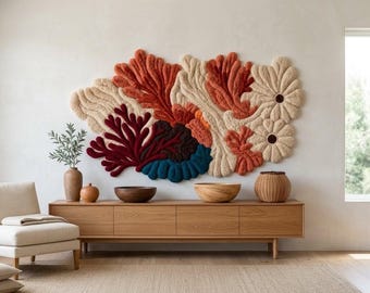 Puede incluir: Un gran tapiz de pared texturizado con formas orgánicas abstractas en tonos crema, terracota, rojo intenso y azul verdoso oscuro. La pieza tiene un aspecto afelpado y con relieve, con formas superpuestas que recuerdan al coral y dos motivos circulares.