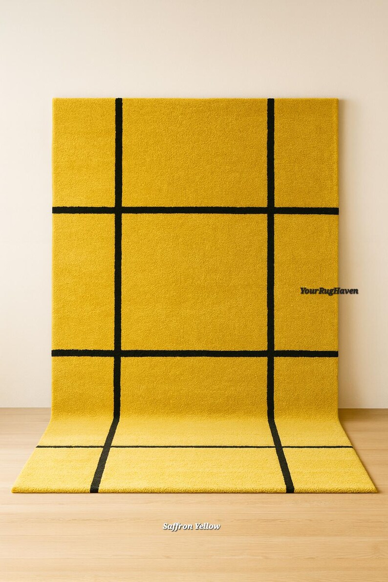 May include: A saffron yellow rug with a bold black grid pattern. The rug is rectangular and has a soft, textured appearance. The text "Your Rug Haven" and "Saffron Yellow" are visible.