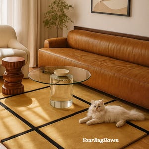 May include: A living room scene featuring a mustard yellow rug with black borders, a brown leather sofa, and a clear glass coffee table. A white cat is lying on the rug. A wooden side table and artwork are also visible.