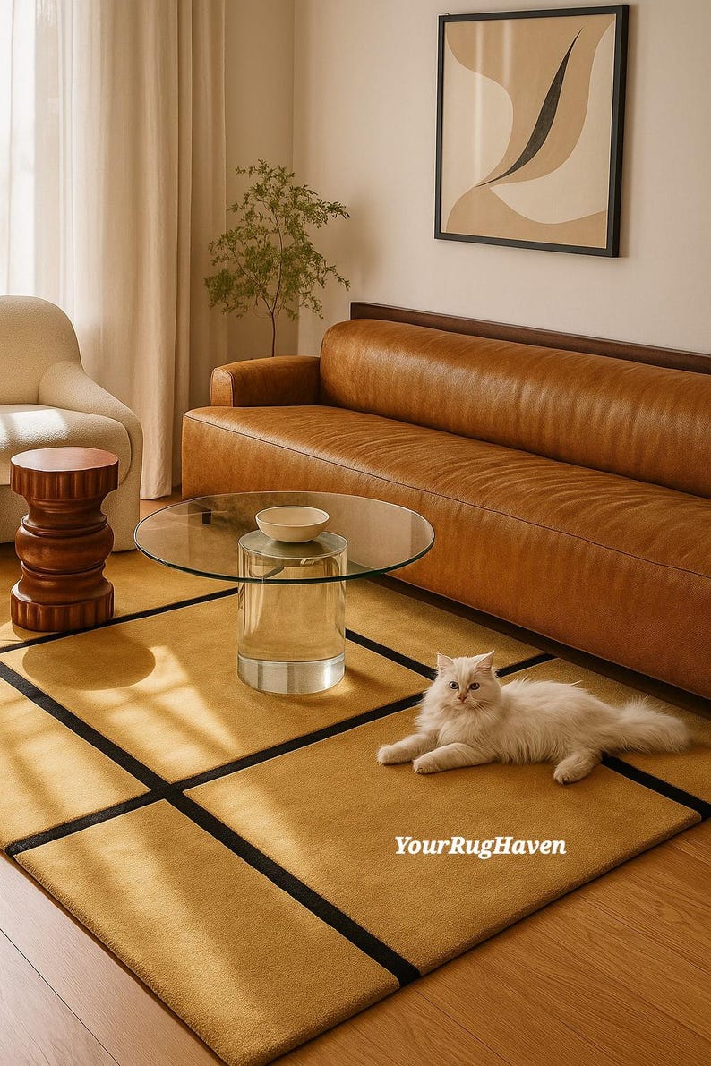 May include: A living room scene featuring a mustard yellow rug with black borders, a brown leather sofa, and a clear glass coffee table. A white cat is lying on the rug. A wooden side table and artwork are also visible.