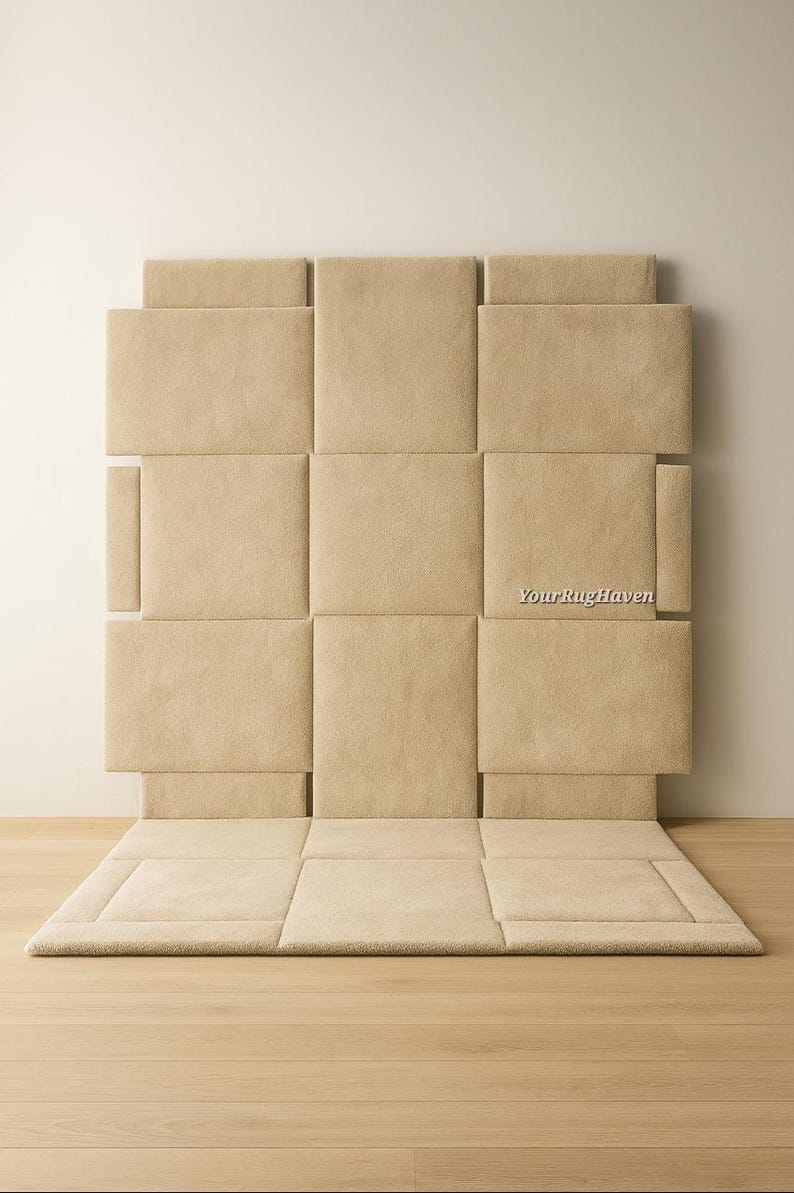 May include: Beige upholstered headboard and rug set. The headboard is composed of square panels, with a matching rug at the base. The text "YourRugHaven" is visible on the headboard. The set is on a light wood floor.