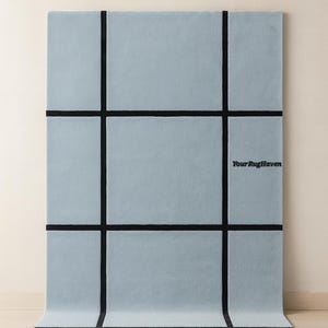 May include: Pale aqua rectangular rug with a grid pattern of thick black lines. The rug has the text "Your RugHaven" and "Pale Aqua" on it. The rug is displayed on a light wood floor.