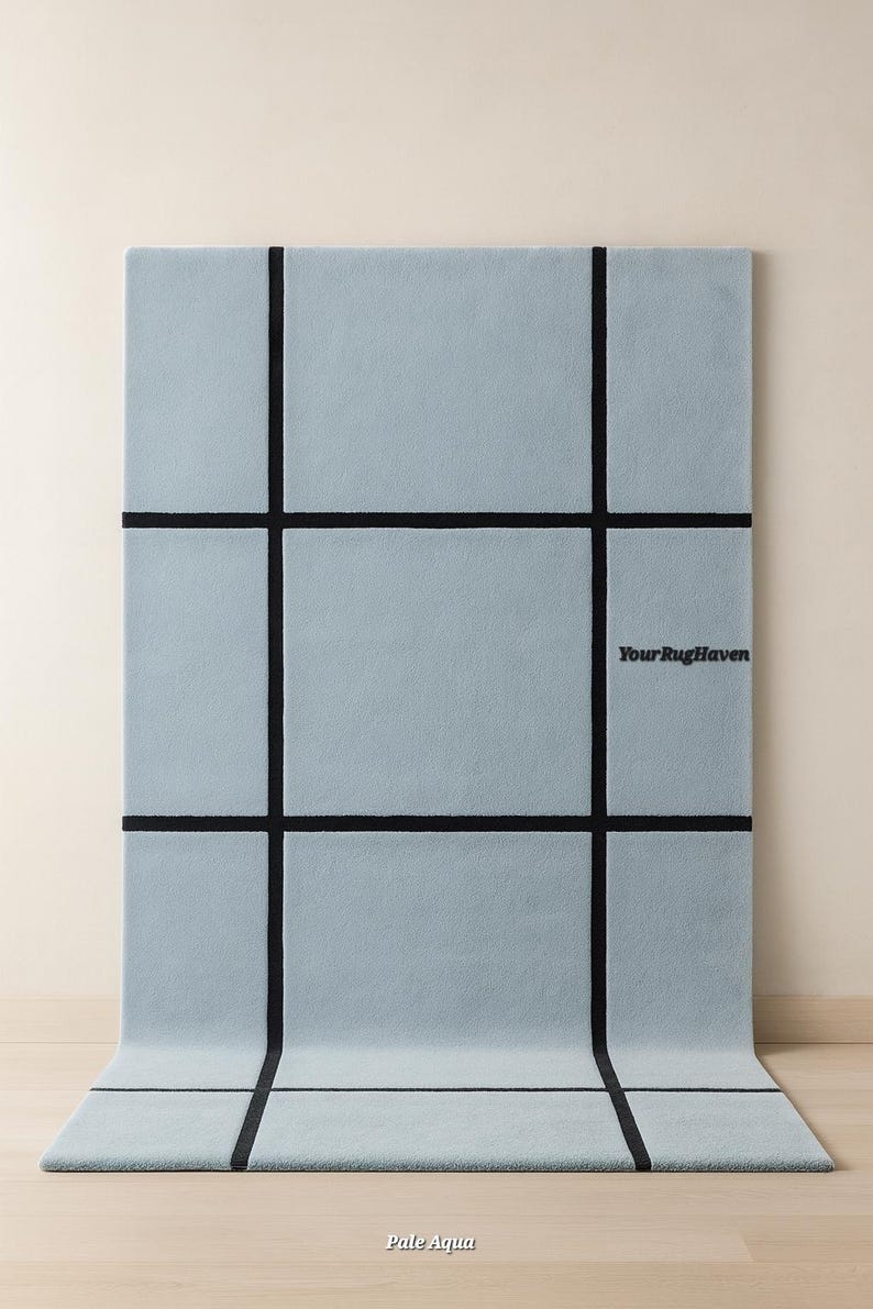 May include: Pale aqua rectangular rug with a grid pattern of thick black lines. The rug has the text "Your RugHaven" and "Pale Aqua" on it. The rug is displayed on a light wood floor.