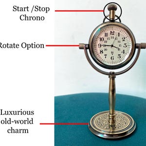 May include: A vintage-style brass clock with a round face and Roman numerals. The clock features a stand and a rotating option, with a start/stop chrono function. The base has an ornate design, and the clock evokes a luxurious, old-world charm.