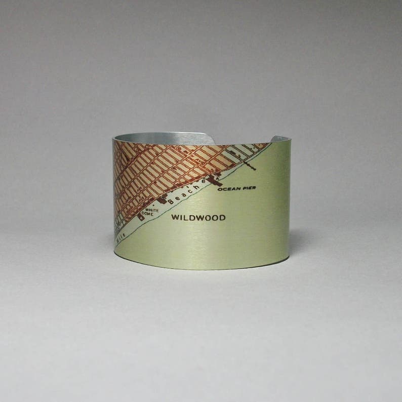 May include: A silver metal cuff bracelet with a vintage map of Wildwood, New Jersey. The map shows the beach, ocean pier, and White Dome.