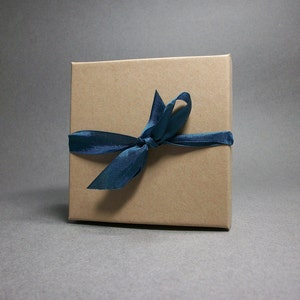May include: A brown gift box with a blue ribbon tied in a bow.
