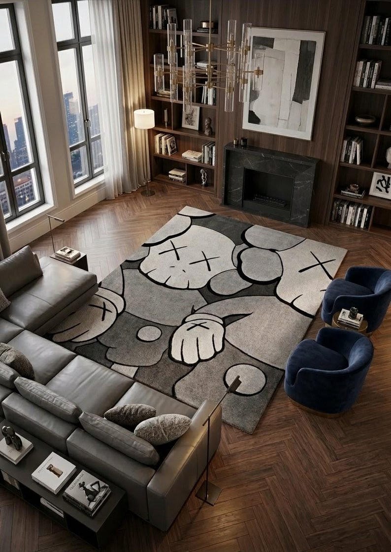 A large 8x10 foot hand-tufted New Zealand wool rug featuring a KAWS style pop art character in grey and slate blue tones on a dark wood chevron floor in a luxury modern living room setting.