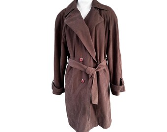 May include: A brown trench coat with a double-breasted design, featuring a matching belt and buttons. The coat has a classic lapel collar and long sleeves with cuff details. The coat is displayed on a white mannequin.