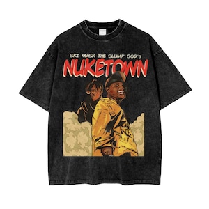 May include: Black t-shirt with a graphic of two people and the text "SKI MASK THE SLUMP GOD'S NUKETOWN" in red and white. The shirt has a vintage, faded look.