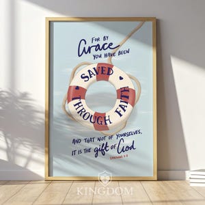 May include: Framed art print featuring a life preserver with the words "Saved Through Faith" and a quote from Ephesians 2:8. The artwork has a light blue background and a wooden frame. The text "For by Grace" is written above the life preserver.