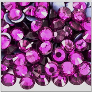 May include: A collection of numerous small, round, faceted magenta rhinestones. Each individual stone features a brilliant cut with multiple reflective surfaces, creating a vibrant, deep pink appearance across the entire group of loose gems.