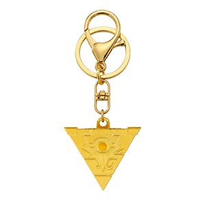 Puede incluir: Un llavero de metal de color dorado con un colgante triangular que presenta un símbolo de ojo grabado en el centro. El colgante está unido a un cierre de mosquetón giratorio y a una anilla circular, todo con un acabado metálico dorado pulido.
