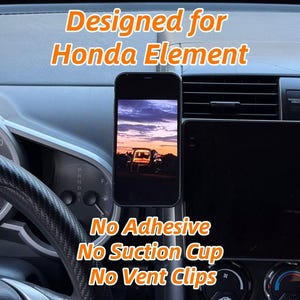 May include: A black smartphone displaying a sunset scene is mounted on a car dashboard. The text "Designed for Honda Element" is above the phone. Below the phone, the text reads "No Adhesive, No Suction Cup, No Vent Clips". The car's steering wheel and dashboard are visible.