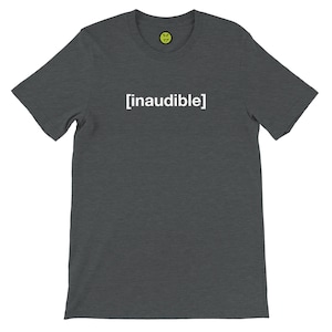 May include: Dark gray t-shirt with the word "[inaudible]" printed in white. A small yellow smiley face logo is visible near the neckline. The shirt is made of a soft material.
