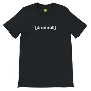 Puede incluir: Camiseta negra con el texto blanco "[drumroll]" centrado en el pecho. En la parte superior hay una pequeña carita sonriente amarilla con un contorno verde. La camiseta tiene mangas cortas y cuello redondo.