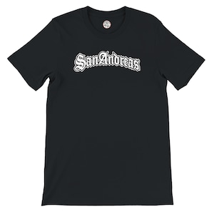 May include: Black t-shirt featuring the white text "San Andreas" in a decorative font. The shirt has a crew neck and short sleeves. A small circular logo is near the neckline.