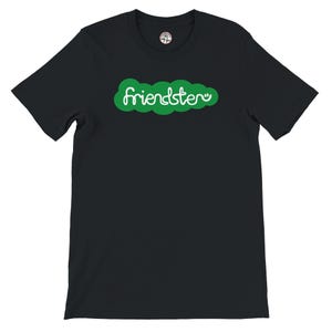 Puede incluir: Camiseta negra con la palabra "friendster" en blanco, dentro de un diseño verde en forma de nube. La camiseta tiene cuello redondo y mangas cortas. El diseño está centrado en el pecho.