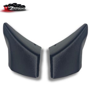 Puede incluir: Dos piezas de automóvil de plástico azul oscuro texturizado se muestran sobre un fondo blanco. Las piezas son imágenes especulares, con un diseño curvo y angular. El logotipo de V.2 Studio está en la esquina superior izquierda.