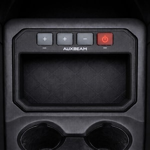 May include: A black automotive center console accessory featuring a rectangular storage compartment with a diamond-patterned base, two circular cup holders, and a control panel labeled AUXBEAM with three buttons marked plus, minus, and a red power icon.
