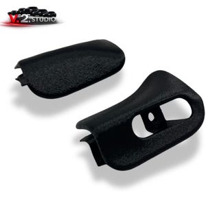 May include: Two black, textured plastic car parts. One is a curved, rectangular piece, and the other has a curved design with a hole. The parts are set against a white background. The logo "V.2. studio" is in the top left corner.
