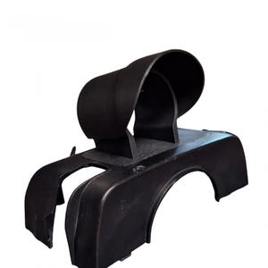 May include: A black plastic automotive part with a curved, hooded top and a base with rounded edges. The part appears to be a component of a vehicle's dashboard or engine compartment.
