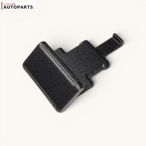 Può includere: Una clip automobilistica in plastica nera con testa rettangolare e linguetta di bloccaggio sporgente, caratterizzata da una finitura superficiale testurizzata. Il componente riporta il testo CUSTOM AUTOPARTS LLC nell'angolo in alto a sinistra.