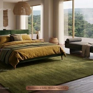 May include: A contemporary bedroom featuring a green rug, a bed with a green headboard and ochre bedding, and a daybed. Large windows provide a view of a waterfall and verdant landscape. Woven baskets and wooden furniture complete the decor.