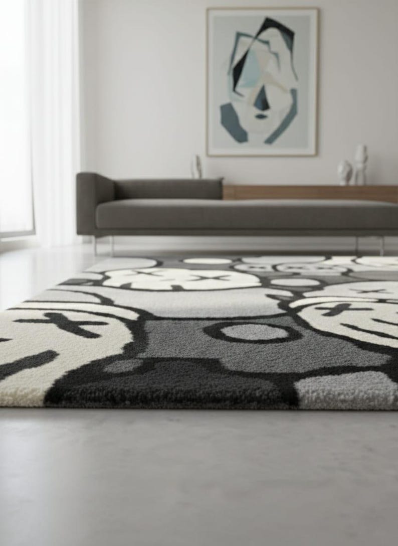 May include: A grey and white patterned rug featuring a repeating cartoon face design. The rug has a plush texture and is in a modern living room. The design includes black outlines and accents.